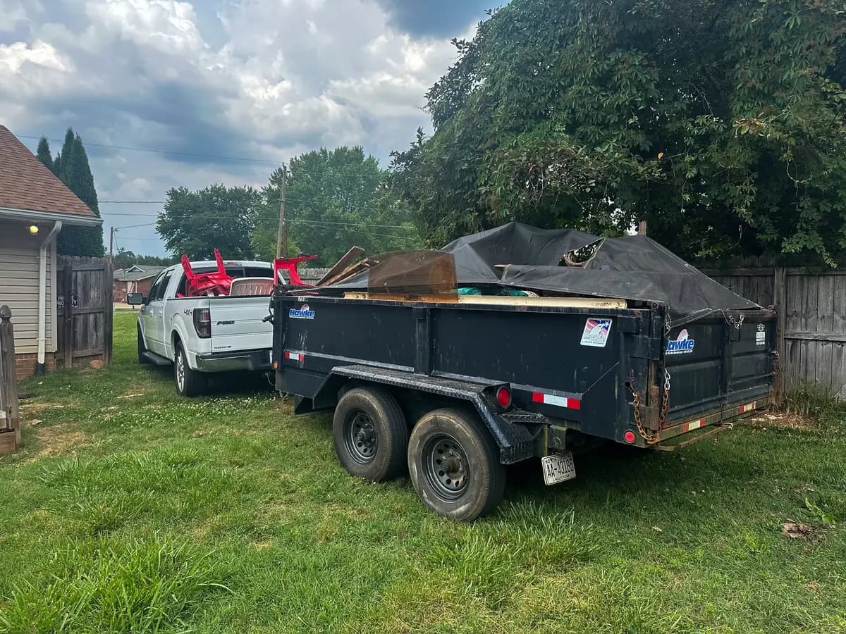 L&S Removal Services trailer loaded with furniture and debris in a backyard